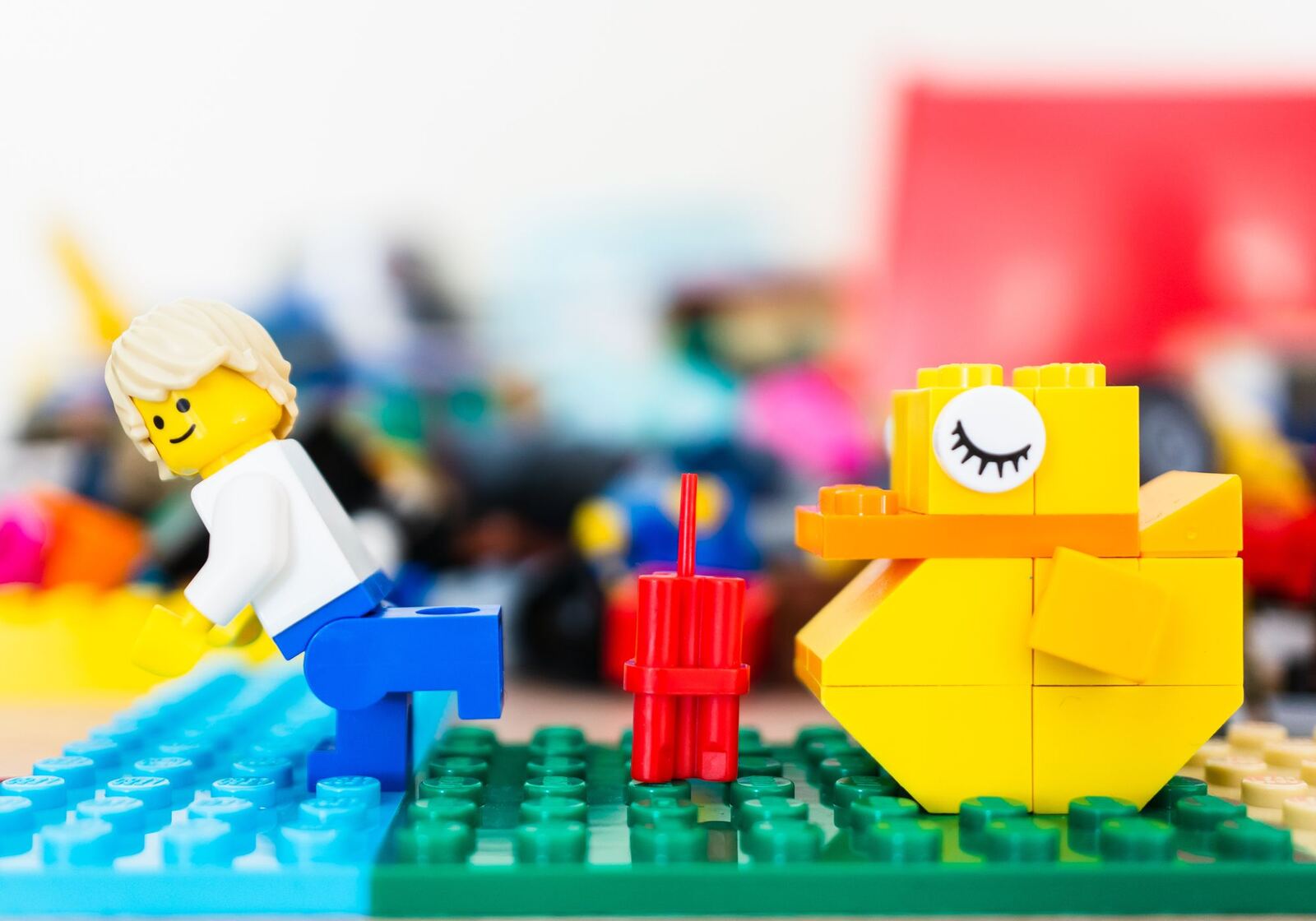 Minifigura y pato construidos con ladrillos LEGO sobre placas de colores, modelos creados durante un taller LEGO SERIOUS PLAY
